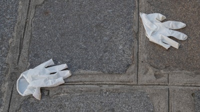 Plastic gloves lays on the ground in Paris on Friday, April 10,during a nationwide confinement to counter the new coronavirus.