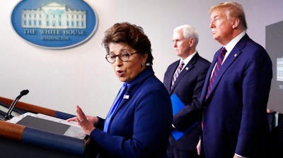 In this Thursday, April 2, 2020 file photo, Jovita Carranza, administrator of the Small Business Administration, speaks about the coronavirus in the James Brady Press Briefing Room of the White House n Washington, as Vice President Mike Pence, President Donald Trump listen. Millions of small businesses are expected to apply for a desperately needed rescue loan Friday, a stern test for a banking industry that has had less than a week to prepare for the deluge. Small businesses will be seeking loans from the $349 billion Paycheck Protection Program, which was put in place to help them retain workers and pay bills during the coronavirus pandemic.