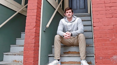 Cameron Karosis, 27, a software salesman, poses for a portrait outside his home, Tuesday, April 14, 2020, in Cambridge, Mass. Karosis usually strives to protect his personal information. But a scary bout with COVID-19 that began with headaches and fevers, progressed to breathing problems and led to a hospital visit has now left him eager to disclose as much as possible to help halt the virus' spread. “I’m sick and I’m under a quarantine -- hold me accountable for it,” he said. “You have the potential to kill other people.”