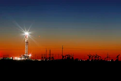 In this Thursday, April 2, 2020 photo, an oil rig lights up the horizon on the outskirts of Midland, Texas after a late sunset.