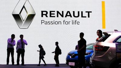 In this April 20, 2017, file photo, visitors walk past the Renault stand during the Auto Shanghai 2017 show in Shanghai, China. Renault SA said Tuesday, April 14, 2020, it will shut down its main China business and focus on electric and commercial vehicles.