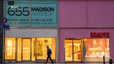 In this Thursday, March 19, 2020, photo, a pedestrian walks past a storefront for rent on Madison Avenue, in New York. Long before there was a global pandemic, brick-and-mortar retailers struggled to resonate as shoppers increasingly made their purchases online. Now, they're faced with an even more daunting task of staying on people's minds and pocketbooks in the midst of the new coronavirus.