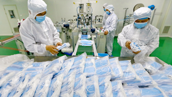 Workers pack surgical masks at a factory in Suining city in southwest China's Sichuan province.