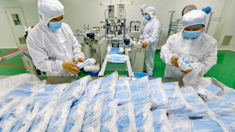 Workers pack surgical masks at a factory in Suining city in southwest China's Sichuan province.