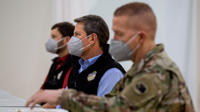 Georgia Gov. Brian Kemp listens to a speaker during a tour of a massive temporary hospital at the Georgia World Congress Center on Thursday, April 16, 2020, in Atlanta.
