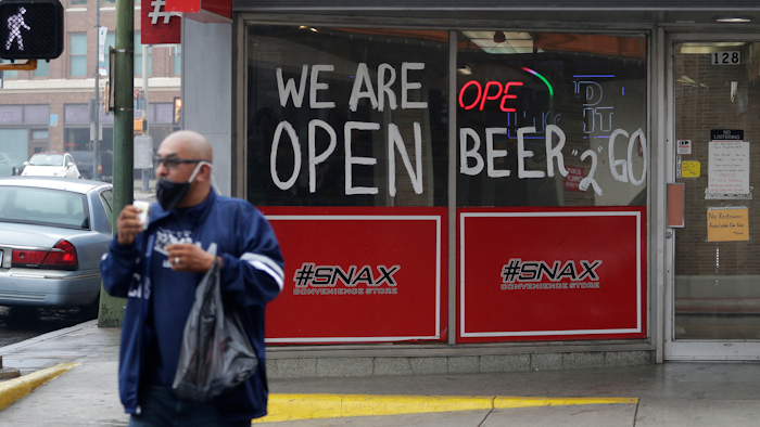 A man wears a face mask as he leaves a business that remains open in downtown San Antonio, Wednesday, April 22, 2020.