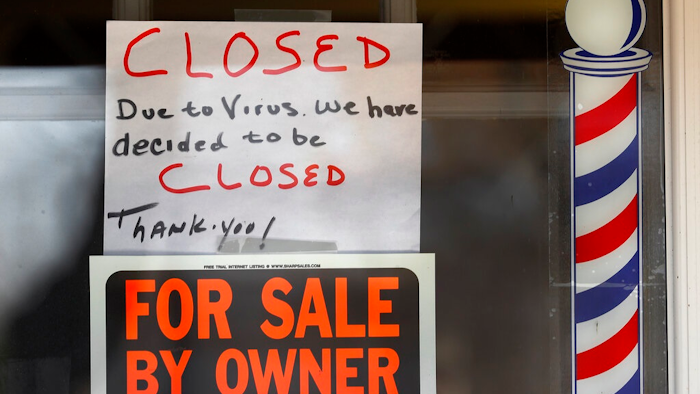 In this April 2, 2020 file photo, 'For Sale By Owner' and 'Closed Due to Virus' signs are displayed in the window of a store in Grosse Pointe Woods, Mich. The second round of loan applications for the government's small business relief program has been slowed by computer issues at the Small Business Administration. Lenders complained Monday, April 27, that they couldn't get their applications into the SBA system known as ETran that processes and approves loans.