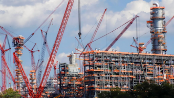 This file photo from Oct. 3, 2019 shows cranes as they work on construction of the Shell Pennsylvania Petrochemicals Complex and ethylene cracker plant located in Potter Township, Pa. Under mounting pressure from state and local officials, Shell announced it is suspending construction at its massive manufacturing complex in western Pennsylvania. The company said Wednesday, March, 18, 2020 that it's temporarily halting work at its soon-to-be-completed plant which will turn the area's vast natural gas deposits into plastics. The shutdown takes effect immediately.