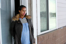 In this April 13, 2020, photo, Kulule Amosa steps out of the apartment she shares with her husband who works at the Smithfield Foods pork processing plant in Sioux Falls, S.D.