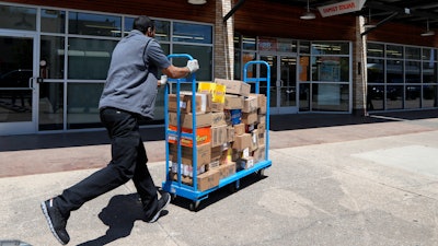 Cameron Webb, an employee with McLane Company, makes a delivery to a Family Dollar in Dallas, Wednesday, April 15, 2020.