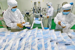 Workers pack surgical masks at a factory in Suining city in southwest China's Sichuan province.