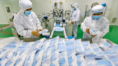 Workers pack surgical masks at a factory in Suining city in southwest China's Sichuan province.