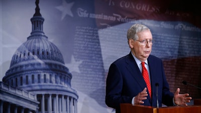 Senate Majority Leader Mitch McConnell speaks with reporters after the Senate approved a nearly $500 billion coronavirus aid bill Tuesday on Capitol Hill in Washington.