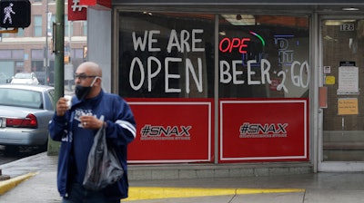 A man wears a face mask as he leaves a business that remains open in downtown San Antonio, Wednesday, April 22, 2020.