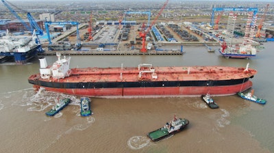 Tugboats push a 300,000-ton very large crude carrier (VLCC) to a shipyard.