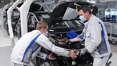 Employees of Volkswagen work with face masks.