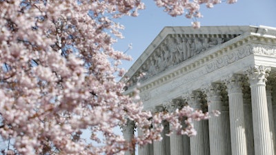 In this March 16, 2020, file photo, a tree blooms outside the Supreme Court in Washington.