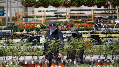 Shoppers look at plants at a nursery in Macomb, Mich., Monday, April 27, 2020.