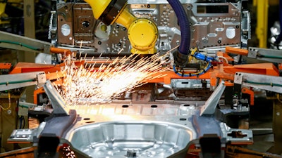 In this June 24, 2019, file photo machines work on a Ford vehicle assembly line at Ford's Chicago Assembly Plant in Chicago.