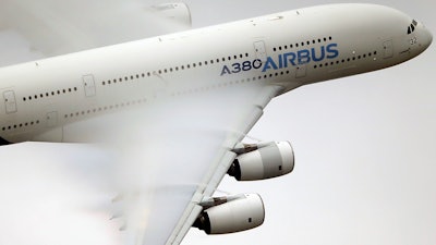 In this June 18 2015 file photo, vapor forms across the wings of an Airbus A380 as it performs a demonstration flight.