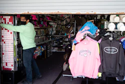 Mohammad Ikram closes a large door to his business Hot Stop, fully stocked but closed during the coronavirus pandemic.