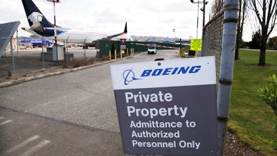 In this April 20, 2020, file photo, planes sit parked behind a sign marking Boeing property at a Boeing production plant in Renton, Wash. Boeing shareholders approved a slate of 12 company-backed nominees for the board on Monday, April 27, despite recommendations from two proxy advisers against five directors, including the chairman, for what the advisers called poor oversight of the company's handling of the 737 Max crisis.
