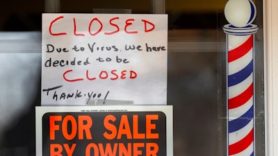 In this April 2, 2020 file photo, 'For Sale By Owner' and 'Closed Due to Virus' signs are displayed in the window of a store in Grosse Pointe Woods, Mich. Business filings under Chapter 11 of the federal bankruptcy law rose sharply in March, and attorneys who work with struggling companies are seeing signs that more owners are contemplating the possibility of bankruptcy. Government aid my simply be too little too late.