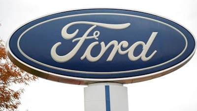 In this Oct. 20, 2019, file photo, the company logo stands over a long row of unsold vehicles at a Ford dealership in Littleton, Colo. Ford Motor Co. posted a $2 billion first-quarter net loss, blaming nearly all of it on the negative effects of the coronavirus.