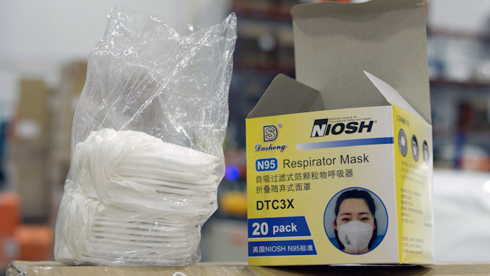 An opened box of protective masks sits on a pallet at Direct Relief's distribution center in Santa Barbara, Calif.