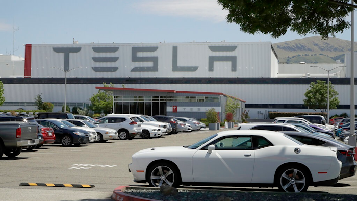 Vehicles are seen parked at the Tesla car plant Monday, May 11, 2020, in Fremont, Calif. The parking lot was nearly full at Tesla's California electric car factory Monday, an indication that the company could be resuming production in defiance of an order from county health authorities.