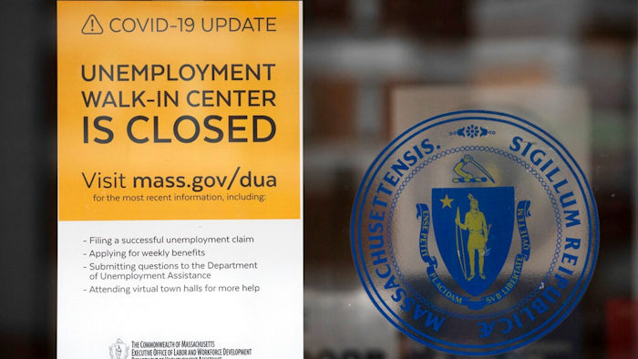 A sign announces the closure of the Massachusetts Unemployment Office, Saturday, May 9, 2020, in Boston.