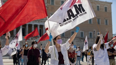 Protesters from the communist party-affiliated PAME union march during a May Day rally outside the Greek Parliament.