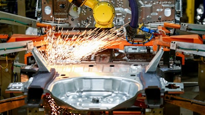 In this June 24, 2019, file photo machines work on a Ford vehicle assembly line at Ford's Chicago Assembly Plant in Chicago.