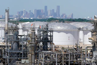 In this April 30 photo, storage tanks at a refinery along the Houston Ship Channel are seen with downtown Houston in the background.