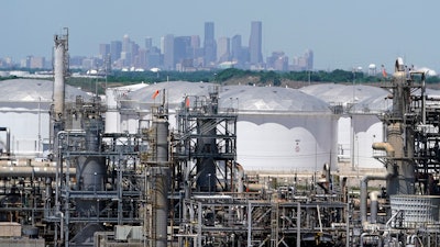 In this April 30 photo, storage tanks at a refinery along the Houston Ship Channel are seen with downtown Houston in the background.