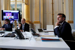 French President Emmanuel Macron, right, and Foreign Minister Jean-Yves le Drian, center, during an international videoconference on vaccination at the Elysee Palace in Paris, May 4, 2020.