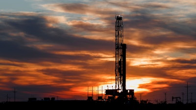 An oil rig stands against the setting sun in Midland, Texas.