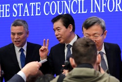 Chinese Commerce Minister Zhong Shan, center, speaks to reporters.