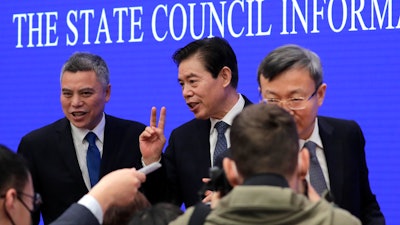 Chinese Commerce Minister Zhong Shan, center, speaks to reporters.