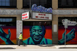 A worker passes a closed nightclub in Austin, Texas, May 18, 2020.