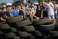 A woman makes a barricade off tyres during a protest by Nissan workers in Barcelona, Spain.