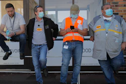 Protesting Renault workers stand outside their plant.