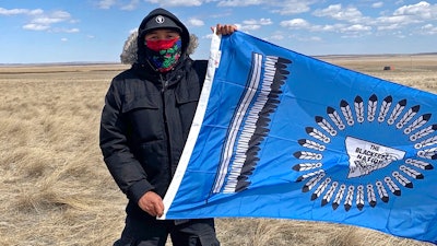 This photo from early May, 2020, provided by Angeline Cheek shows Curtis Yazzie as he demonstrates at a construction site for the XL Pipeline just inside the U.S.-Canadian border near Saco, Mont. Members of several tribes in Montana and North Dakota traveled to the border crossing for a small protest against the pipeline earlier this month, according to Cheek, an activist from Montana's Fort Peck Tribe and organizer for the ACLU of Montana. Calgary-based TC Energy has built the first piece of the disputed Keystone XL oil sands pipeline across the U.S. border and started work on labor camps in Montana and South Dakota.