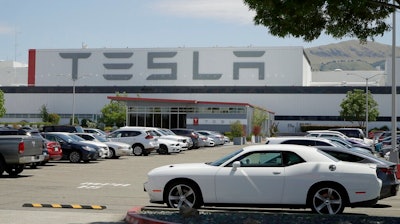 Vehicles are seen parked at the Tesla car plant Monday, May 11, 2020, in Fremont, Calif. The parking lot was nearly full at Tesla's California electric car factory Monday, an indication that the company could be resuming production in defiance of an order from county health authorities.