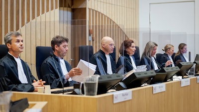 Presiding judge Hendrik Steenhuis, third from left, opens the court session as the trial resumed at the high security court building at Schiphol Airport, near Amsterdam.