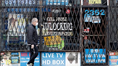 A man walks by a closed store.