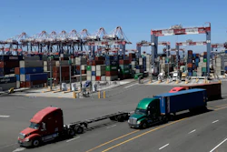 Trucks travel along a loading dock at the Port of Long Beach in Long Beach, Calif., Aug. 22, 2018.