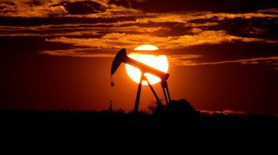 In this Wednesday, April 8, 2020, file photo, the sun sets behind an idle pump jack near Karnes City, Texas.