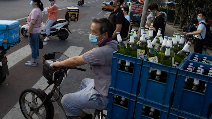 A delivery man transports beer on the streets of Beijing.