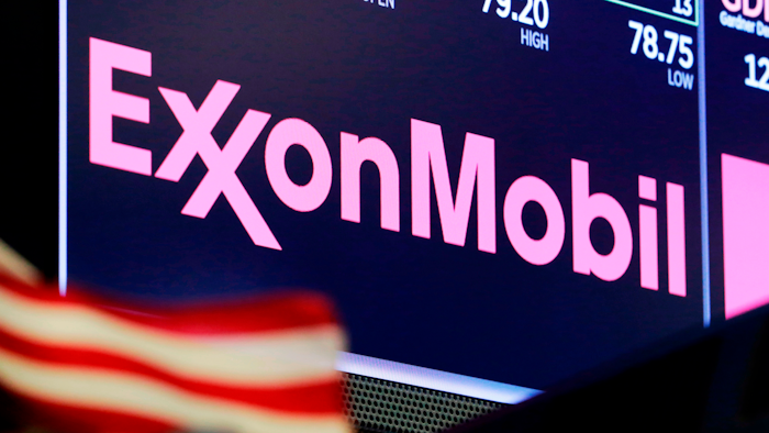 The logo for ExxonMobil appears above a trading post on the floor of the New York Stock Exchange.